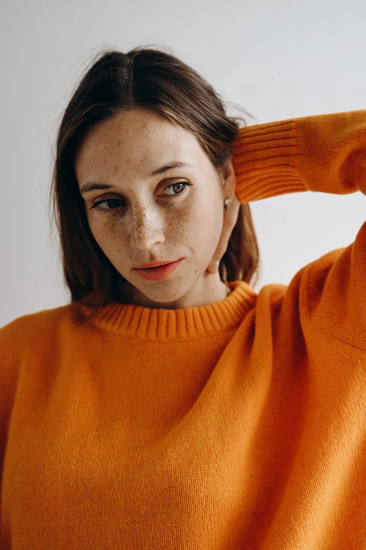 A girl wearing an orange sweater