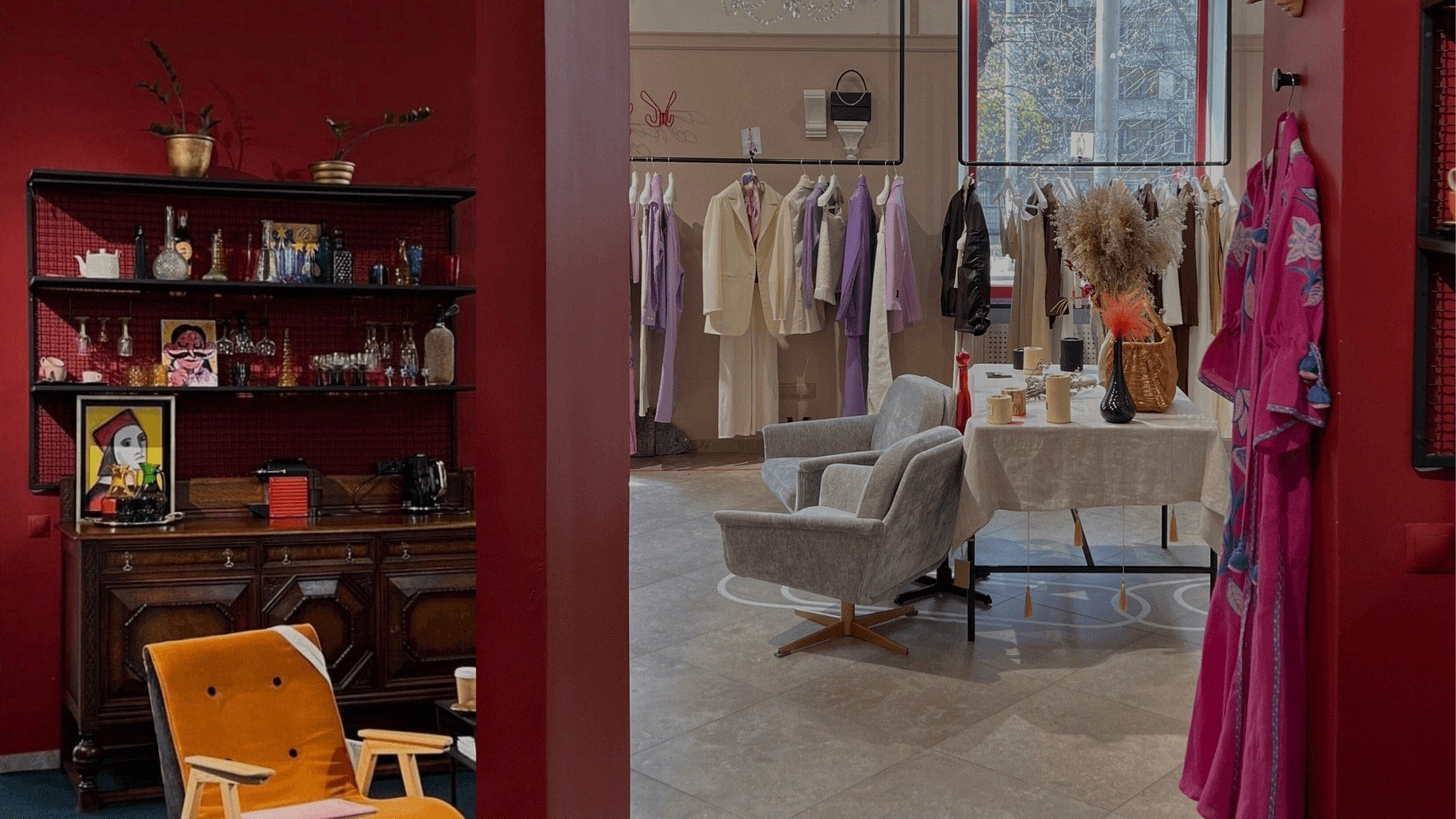 Stylish boutique interior with clothing racks, lounge area, and red accent walls